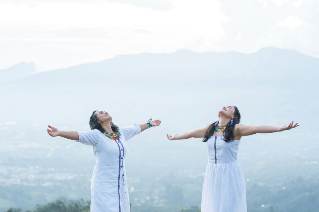 indigenous women with open arms looking at the sky in nature. spiritual moment full of peace